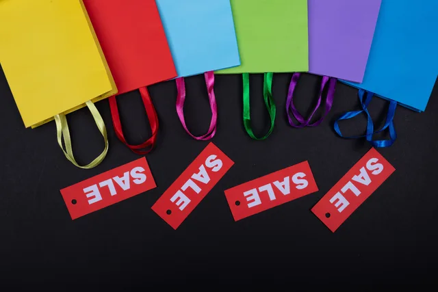Vibrant shopping bags with sale tags on a black surface. Perfect for retail promotions. Ecommerce SEO strategy mistakes explained for English store teams