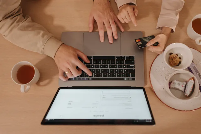 Two people using a laptop for online shopping with a credit card, seen from above. UK GDPR and ICO consent rules for ecommerce SEO tracking